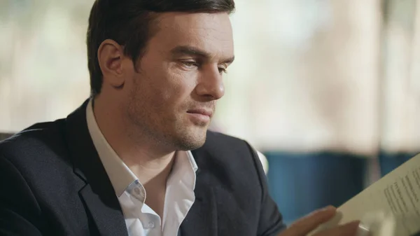 Businessman looking restaurant menu. Business man choosing lunch in menu at cafe