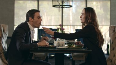 Restoranda yemek yiyen romantik bir çift. Erkek kadına romantik bir akşam yemeğinde yemek verir.