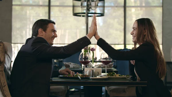 Šťastný pár dává ruku v restauraci. Muž a žena cinkající víno sklo — Stock fotografie