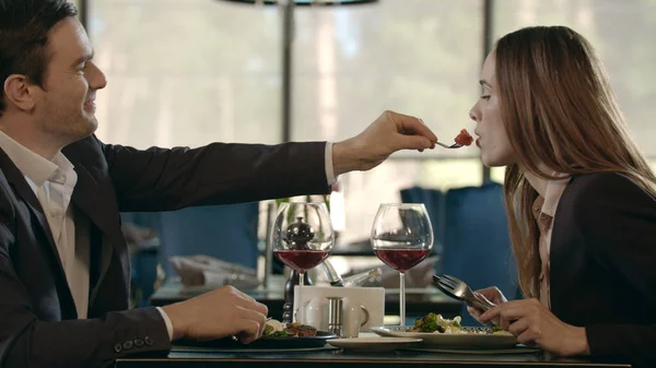 Handsome man feeding woman at romantic dinner. Couple dining at romantic date — Stock Photo, Image