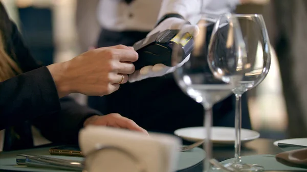 Kvinnelig mann som betaler med bankkort i restaurant. Kontaktløs betaling – stockfoto