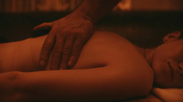 Close-up de mãos de homem fazendo massagem em câmera lenta. Corpo feminino recebendo massagem — Fotografia de Stock