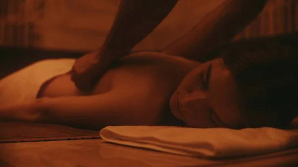 Mãos de homem fazendo massagem no spa. Menina relaxada deitada no spa . — Fotografia de Stock