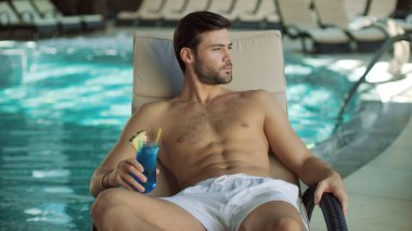 Modern Spa 'da kokteyl içen yakın arkadaş. Havuz kenarında rahatlayan bir adam.