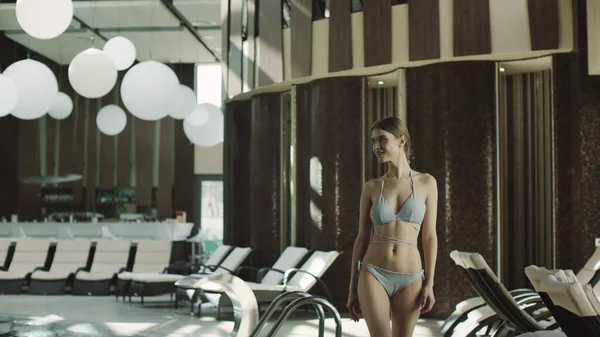 Havuzun yanında yürüyen güzel bir kadın. Güzel kız havuz kenarında dinleniyor.