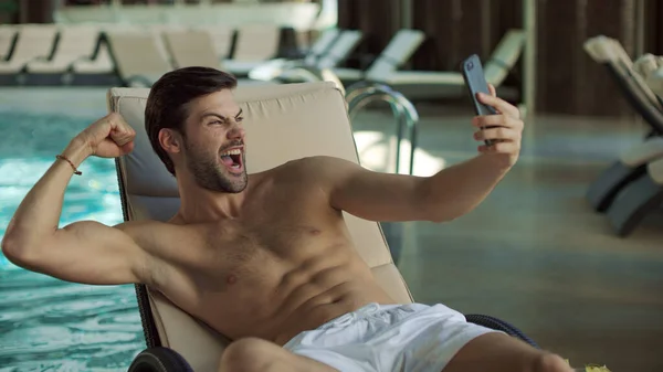 Gros plan homme s'amuser près de la piscine intérieure. Homme faisant selfie sur téléphone mobile — Photo