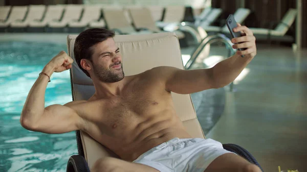 Knappe man maakt zelfportret op mobiele telefoon aan het zwembad — Stockfoto