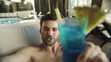 Otelde bilardo oynayıp kokteyl içen adama yakın durun. Mutlu adam video kaydediyor