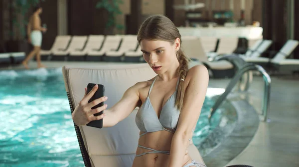 Porträt einer jungen Frau macht Selfie auf Liege in Schwimmbadnähe. — Stockfoto