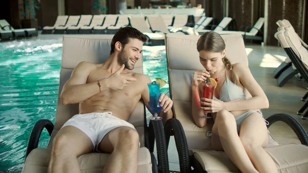 Pareja cercana bebiendo cócteles en las tumbonas. Hombre y mujer relajándose juntos —  Fotos de Stock
