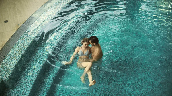 Vista superior sonriente pareja nadando en la piscina. Preciosa familia descansando en el jacuzzi —  Fotos de Stock
