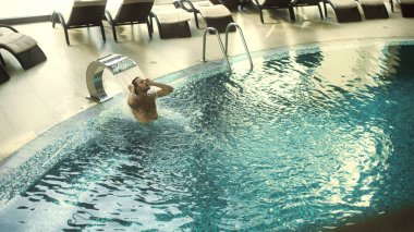 Su jetini seven yakışıklı bir adamın manzarasının üstünde. Adam su tedavisi görüyor..