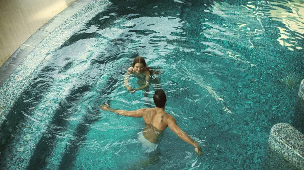 Draufsicht auf fröhliches Paar im Pool-Innenbereich. Paar hat Spaß im Whirlpool — Stockfoto