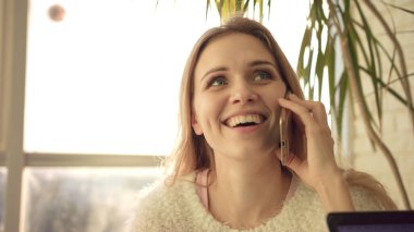 Sarışın kadın telefonda konuşuyor. Cep telefonuyla konuşan çalışan kadının portresi