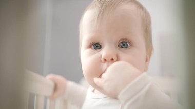 Küçük bebek parmağını ısırıyor. Ağızda çocuk parmağı