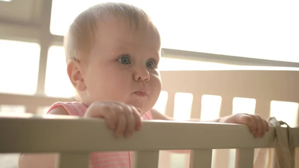 Nettes Baby, das im Kinderbett steht. Nette Kindheit. Kleinkind Mädchen in der Krippe — Stockfoto