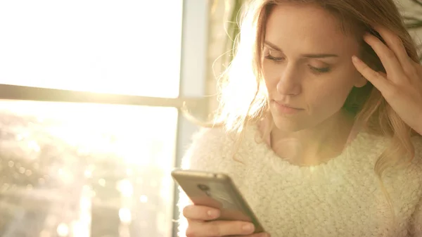 Egy boldogtalan nő sms-ezik mobilon. Zaklatott nő okostelefonnal — Stock Fotó