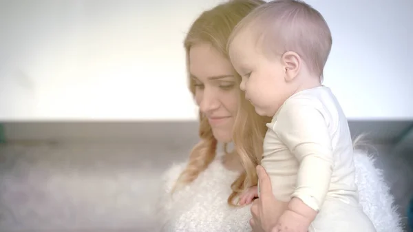 Mutter lächelt für Säugling im weißen Zimmer. Mutter glücklich mit Kind — Stockfoto