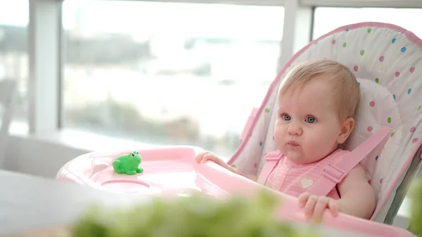 美人の赤ん坊がリンゴを食べる。幼児は手から食べ物を逃した。赤ん坊の果物を食べる — ストック写真