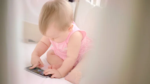 Baby playing with smartphone. Kid girl watching cartoon on mobile