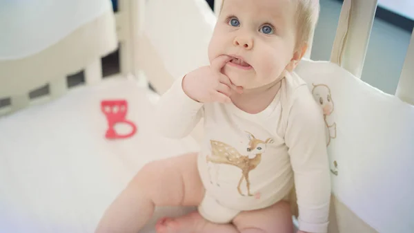 Kleine baby zittend in bed en groeiende vinger. Ontevreden kind — Stockfoto