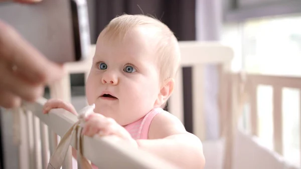 Kleines Baby aussehendes Handy. Lächelndes Kind schaut Smartphone — Stockfoto