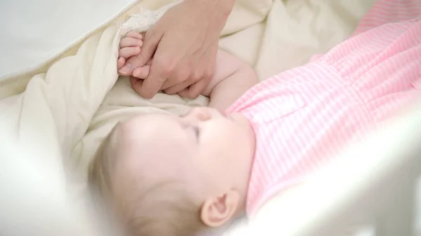 Een klein meisje dat in bed slaapt. Moeder hand strelen slapend kind — Stockfoto