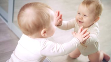 Küçük bebek aynayla oynuyor. Tatlı çocuk aynası. Sevimli çocuk oyunu evi.