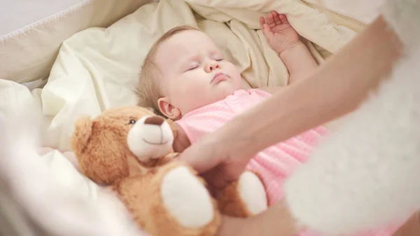 Mutter legt Spielzeug auf schlafendes Baby im Kinderbett Liebenswerter Babyschlaf im Kinderbett — Stockfoto