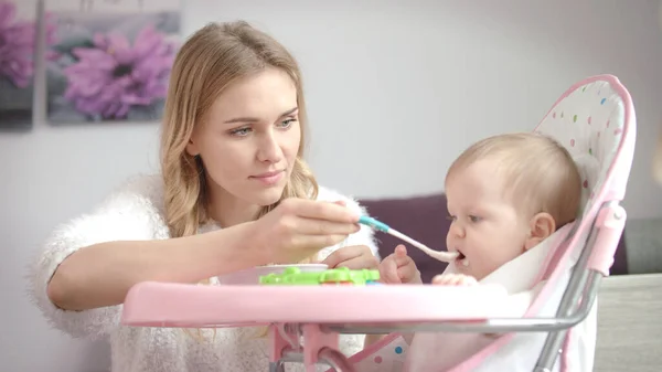 Baby wil geen eten. Moeder voeden kind met pap — Stockfoto