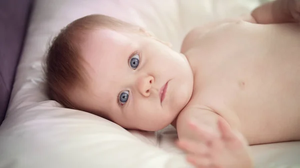 Bebé desnudo acostado en la cama. Dulce entorno de aprendizaje infantil —  Fotos de Stock