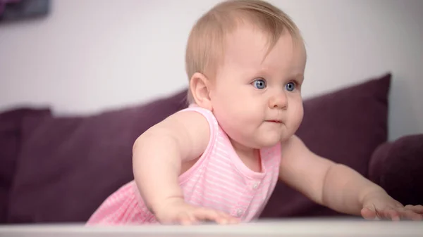 Wunderschönes Baby, das auf dem Sofa steht. Süßes Kind lernt laufen — Stockfoto