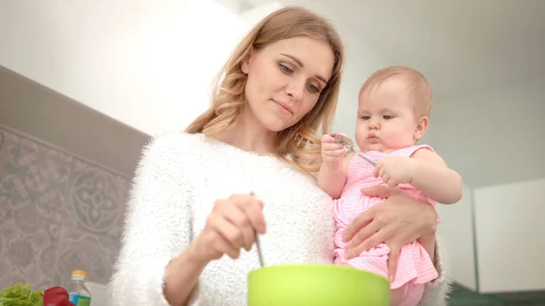 Mooie moeder die kookt met dochter. Moeder met kind op keuken — Stockfoto