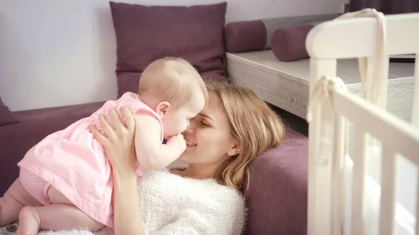Νεαρή μητέρα φιλάει το μωρό στο σπίτι. Έννοια αγάπης και ευτυχίας — Φωτογραφία Αρχείου