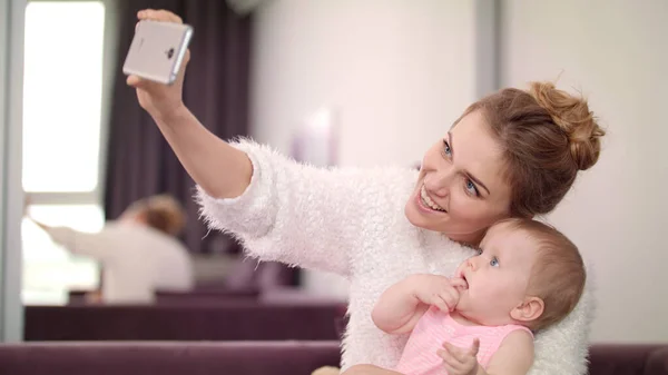 Güzel bir kadın bebekle selfie çekiyor. Anne ve çocuk fotoğraf çekiyorlar. — Stok fotoğraf