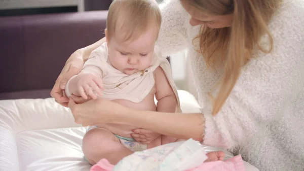 Mom undressing baby. Infant going for a walk. Baby unclothing on bed — Stock Photo, Image