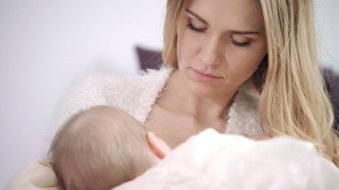 Genç anne yeni doğan çocuğu emziriyor. Anneliğin tadını çıkar.