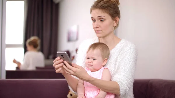 Evde elinde bebek telefonu olan bir kadın. Çalışan anne. Günlük kadın hayatı. — Stok fotoğraf