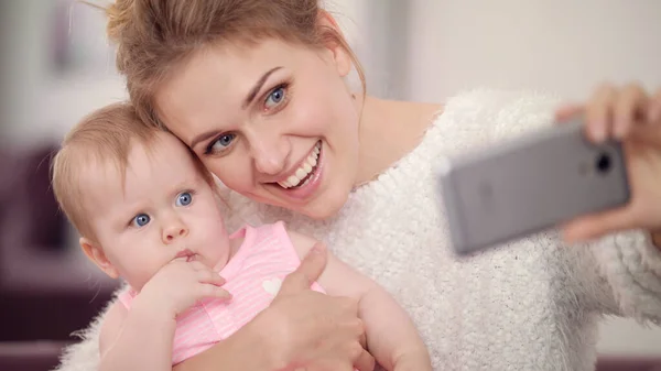 Mãe sorridente fazendo foto selfie com bebê menina. Mulher com criança foto móvel — Fotografia de Stock