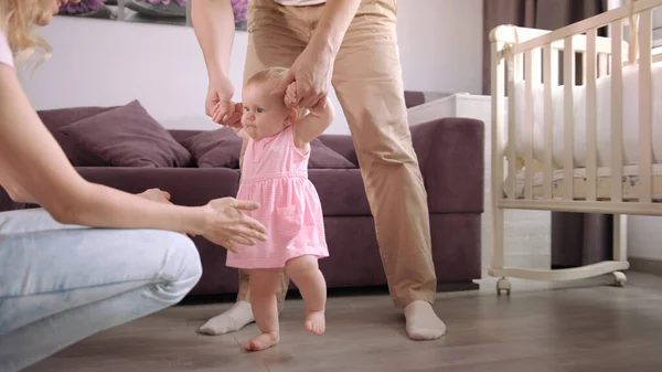 Bebek ilk adımlar. Bebek yürümeyi öğreniyor. Aile desteği küçük çocuk.