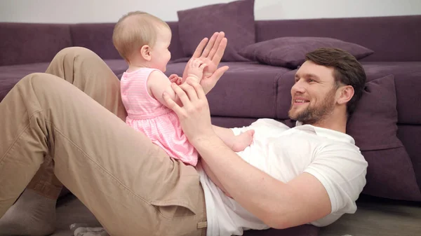 Baba ve bebek el oynuyor. Gülümseyen baba ve küçük kız ellerinizle oynuyorsunuz. — Stok fotoğraf