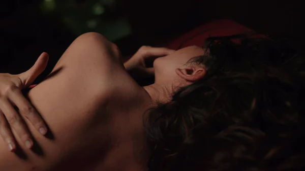 Nackte Mädchen, die rotes Seidenbetttuch bedecken. Junge Frau umarmt sich im Schlafzimmer. — Stockfoto