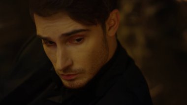 Koyu arkaplanda başka tarafa bakan yakışıklı bir adam. Tarz sahibi adam bir şeyler düşünüyor..