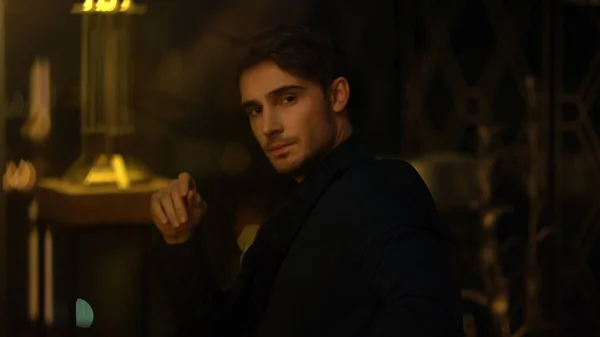 Odaklanmış patron rahat bir poz alıyor. Güzel adam kameraya bakıyor..