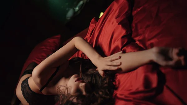 Mooie haarvrouw die handen kruist op satijnen lakens. Sexy meisje liggend op zijden bed — Stockfoto