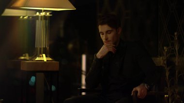 Koltukta kafa yoran güzel bir adam. Kapalı alanda çeneye dokunan zarif bir adam..