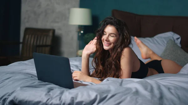Fille saluant interlocuteur lit écran d'ordinateur portable. Femme sexy relaxant avec ordinateur. — Photo