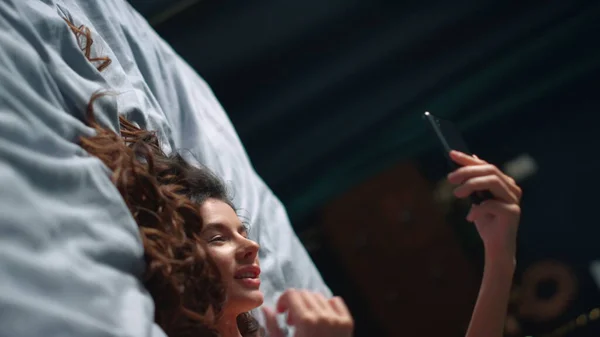 Ładna pani robi łóżko na telefon komórkowy. Kobieta zmysłowa relaksująca się przy telefonie — Zdjęcie stockowe