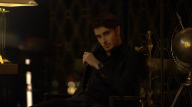 Karanlık odada birini bekleyen seksi bir adam. İçeriye bakan kendine güvenen bir adam..