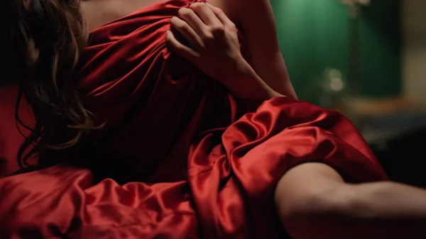 Onbekende vrouw die rode zijden lakenkamer bedekt. Onherkenbaar meisje ontspannend bed. — Stockfoto